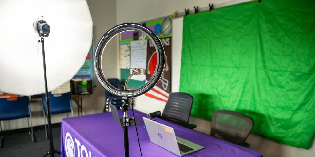 Toledo Prep recording area with a green screen, studio lights, and laptop