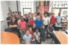 Group of children and adults posing in a classroom.
